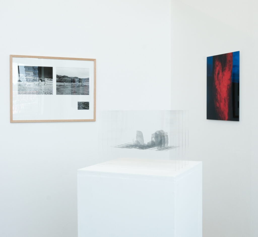 Corner of a gallery, with a framed work, a plinth with a sculpture, and a frameless work