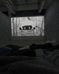 Image of projection on wall. The projection shows the main character face on.