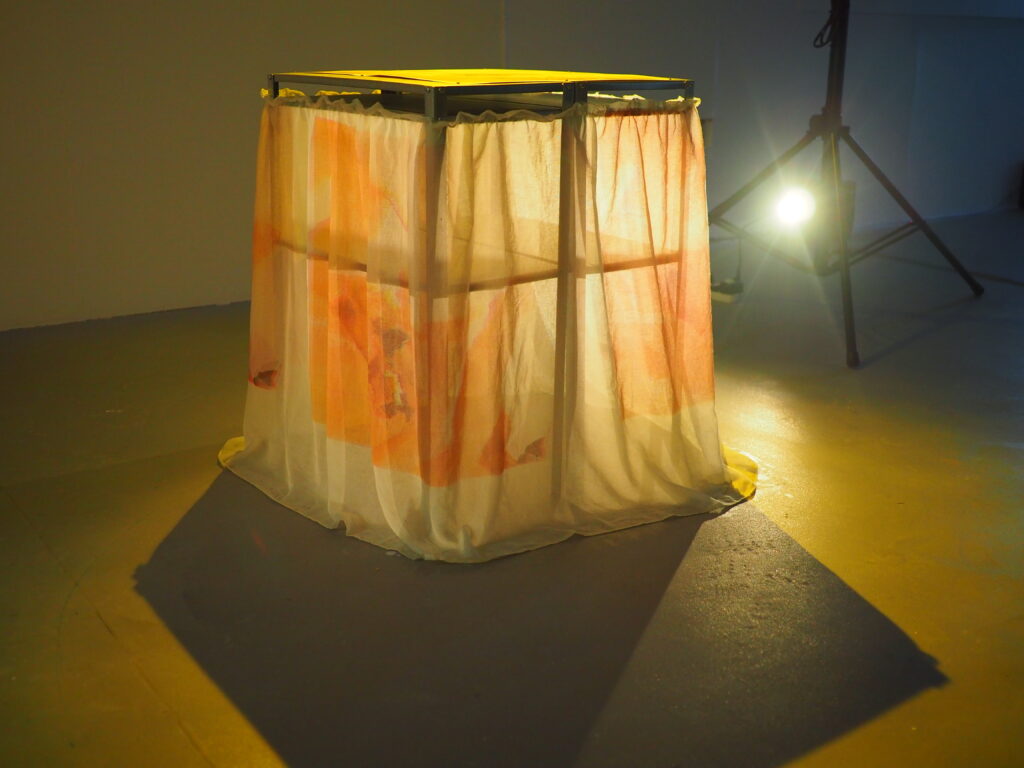 table with colourful draping lit up from behind by a spotlight