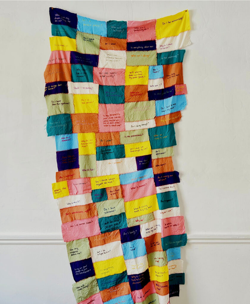 Hand stitched textile work with hand embroidered writing
