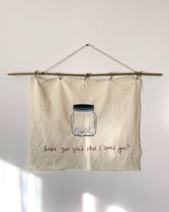 Hand stitched tapestry with bird inside glass jar and text that reads "Aren't you glad that I saved you?"
