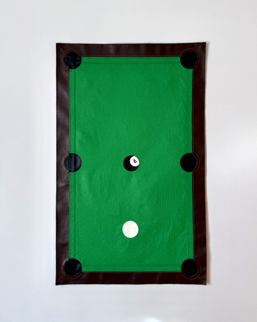 Tapestry that looks like a pool table with eight ball in the middle and white ball directly below it
